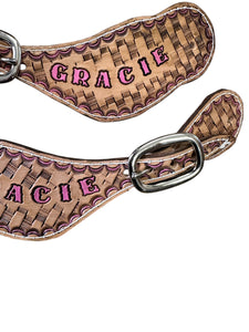 Hand tooled and painted basket weave pink spur straps.